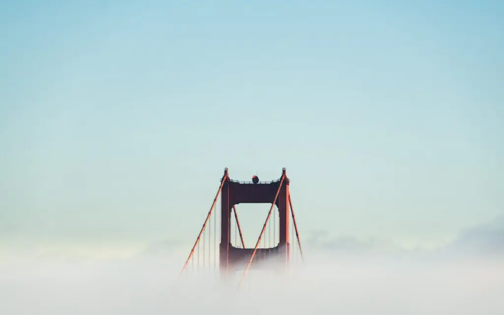 A Golden Gate Bridge tower rising above the fog